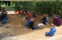 Kinder graben mit kleinen Schaufeln im Sand